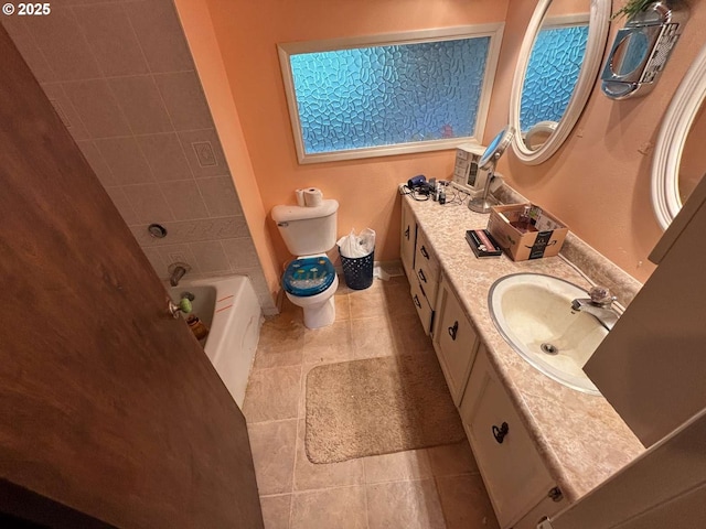 bathroom featuring vanity, toilet, baseboards, and tile patterned flooring