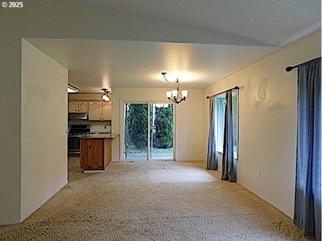 unfurnished living room with sink and a chandelier