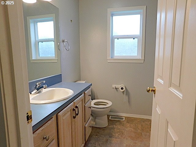 bathroom featuring vanity, toilet, and a wealth of natural light