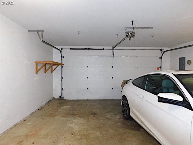 garage featuring electric panel and a garage door opener