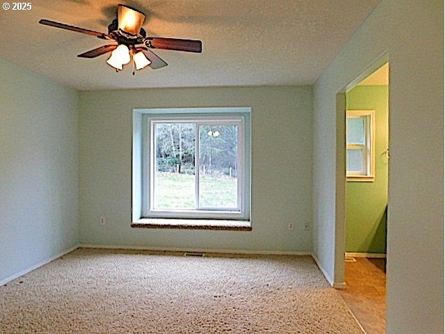 unfurnished room with light carpet and ceiling fan