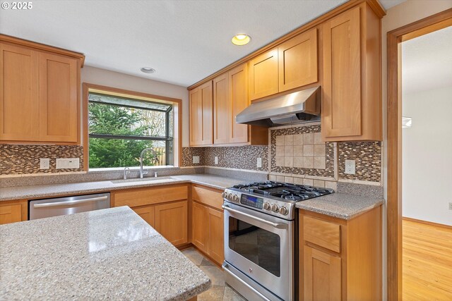 14100 SE 20th St, Vancouver, WA 98683 - kitchen with under cabinet range hood, stainless steel appliances, a sink, recessed lighting, and backsplash