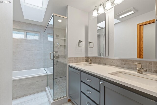 14100 SE 20th St, Vancouver, WA 98683 - bathroom featuring a skylight, a tile shower, double vanity, tiled tub, and decorative backsplash