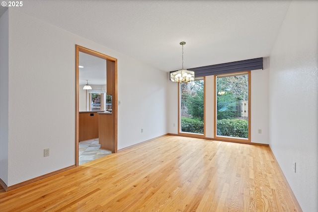 14100 SE 20th St, Vancouver, WA 98683 - spare room featuring wood finished floors, a chandelier, and baseboards