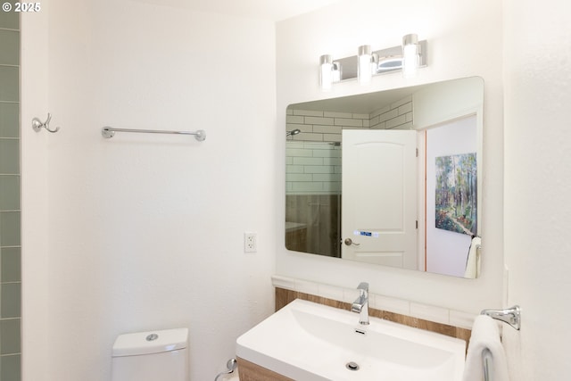bathroom featuring vanity, toilet, and decorative backsplash