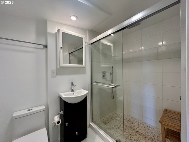 bathroom with vanity, toilet, and a shower stall