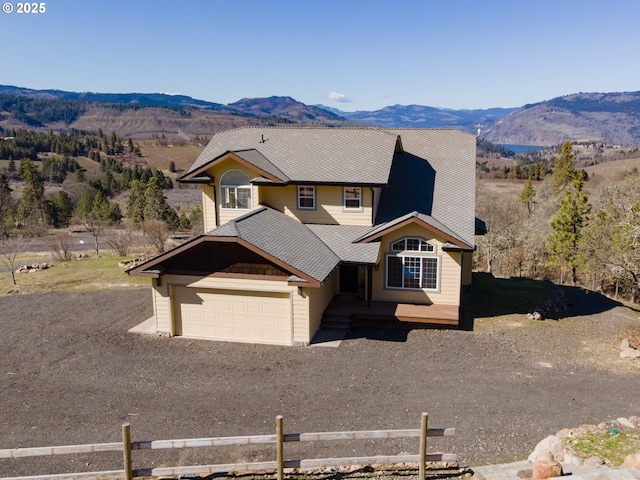 view of front of house with an attached garage, a mountain view, and driveway
