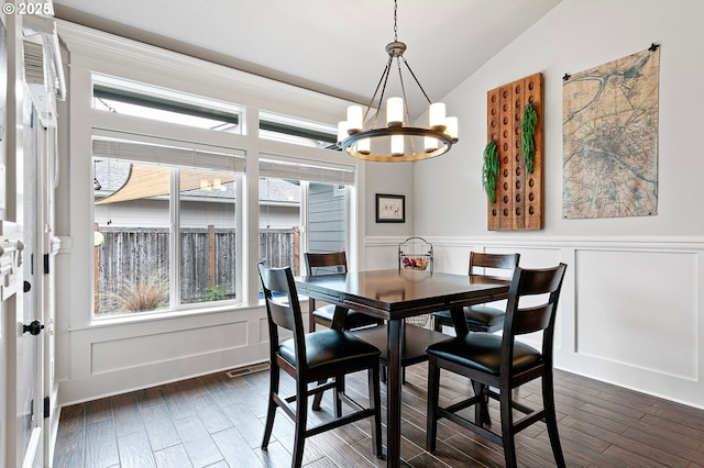 1622 Provincial Way, Eugene, OR 97401 - dining space featuring a chandelier, a decorative wall, dark wood-type flooring, lofted ceiling, and a wainscoted wall