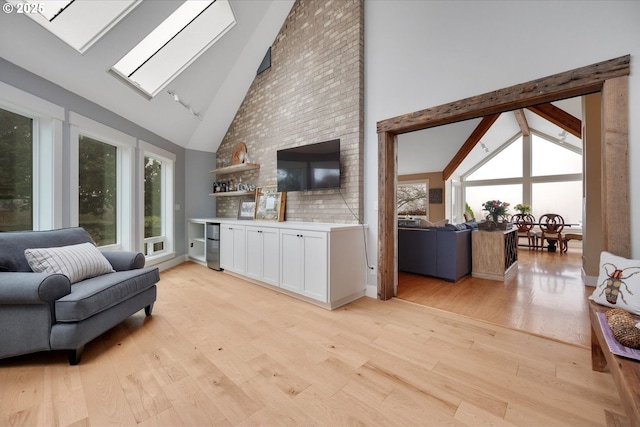 living room with plenty of natural light, light hardwood / wood-style floors, and a skylight