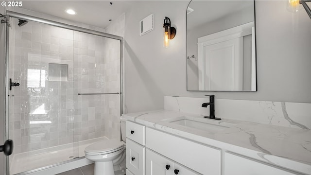 bathroom featuring tile patterned flooring, toilet, vanity, and walk in shower