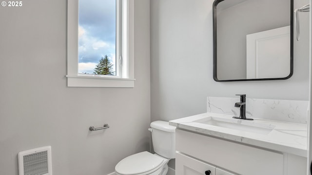 bathroom featuring vanity, toilet, and heating unit