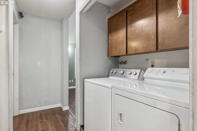 clothes washing area with cabinets, dark hardwood / wood-style floors, a textured ceiling, and independent washer and dryer