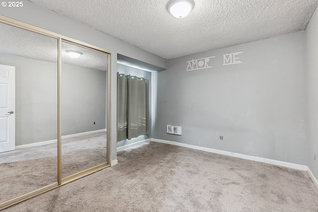 unfurnished bedroom with a closet, carpet, and a textured ceiling