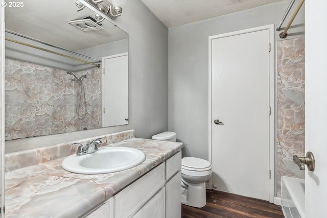 full bathroom featuring vanity, wood-type flooring, washtub / shower combination, and toilet