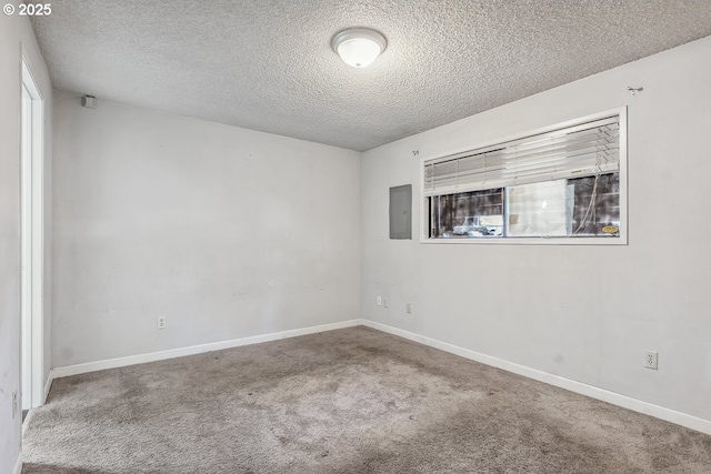 empty room with carpet flooring, electric panel, and a textured ceiling