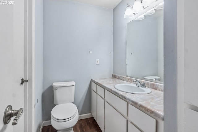 bathroom featuring vanity, wood-type flooring, and toilet