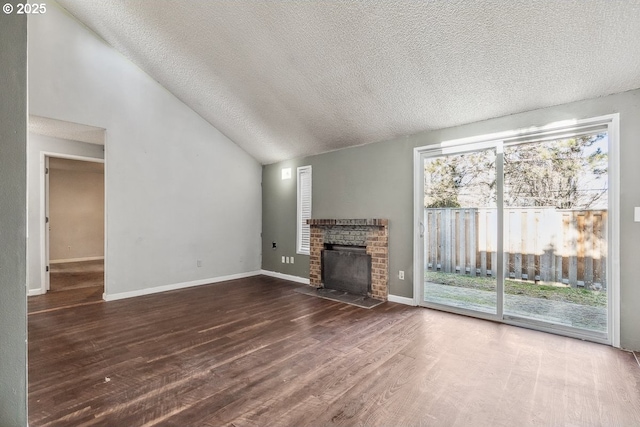 unfurnished living room featuring wood-type flooring, vaulted ceiling, a textured ceiling, and a fireplace