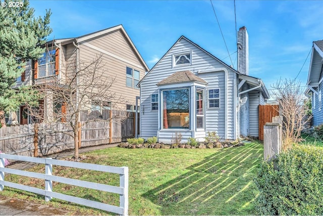 view of front of home with a chimney, a front lawn, and fence