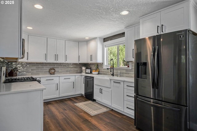 1552 59th Ave SE, Salem, OR 97317 - kitchen with stainless steel fridge, a sink, dishwashing machine, a textured ceiling, and white cabinets