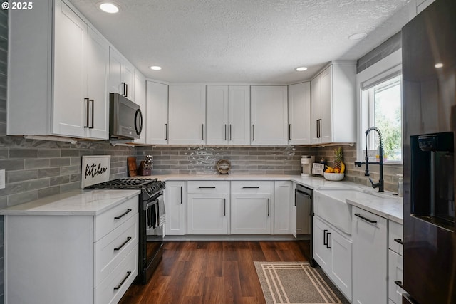 1552 59th Ave SE, Salem, OR 97317 - kitchen with black appliances, a textured ceiling, dark wood finished floors, light stone counters, and a sink