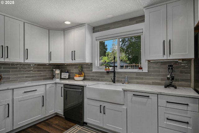 1552 59th Ave SE, Salem, OR 97317 - kitchen featuring dishwashing machine, a textured ceiling, a sink, tasteful backsplash, and dark wood-type flooring