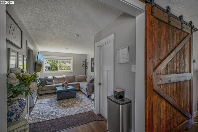 1552 59th Ave SE, Salem, OR 97317 - living area featuring a textured ceiling, a barn door, and wood finished floors
