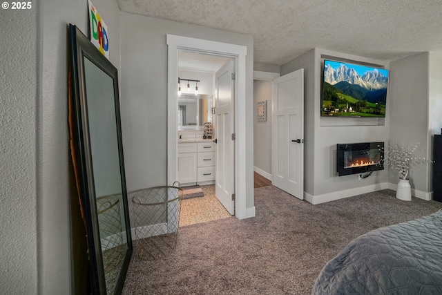 1552 59th Ave SE, Salem, OR 97317 - carpeted bedroom with a glass covered fireplace, baseboards, a textured ceiling, and ensuite bathroom