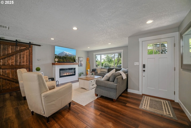 1552 59th Ave SE, Salem, OR 97317 - living area featuring a textured ceiling, dark wood finished floors, recessed lighting, baseboards, and a glass covered fireplace