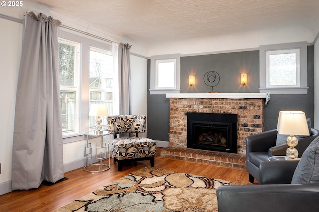 living room with hardwood / wood-style flooring, a fireplace, and a textured ceiling