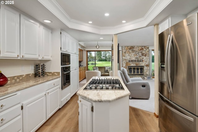 863 Fairway View Dr, Eugene, OR 97401 - kitchen with stainless steel appliances, a center island, light wood-type flooring, ornamental molding, and white cabinets