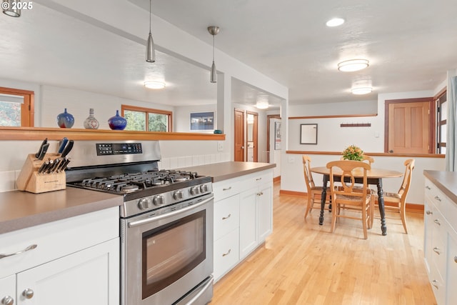 kitchen with gas range, white cabinets, and light wood-style floors