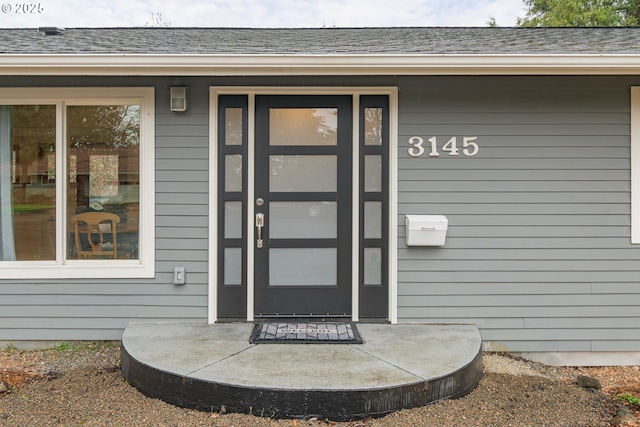 property entrance with a shingled roof