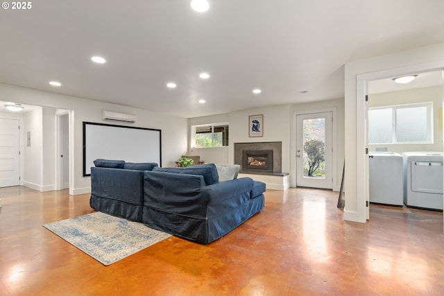 living area with washer and dryer, a healthy amount of sunlight, recessed lighting, and a wall mounted AC