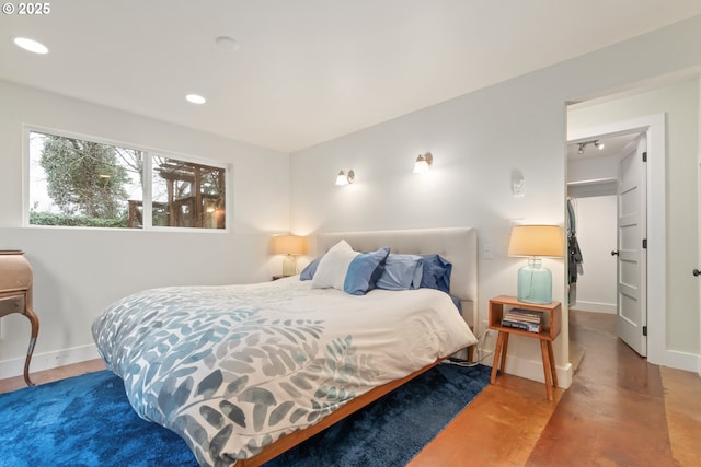 bedroom with finished concrete flooring, recessed lighting, and baseboards