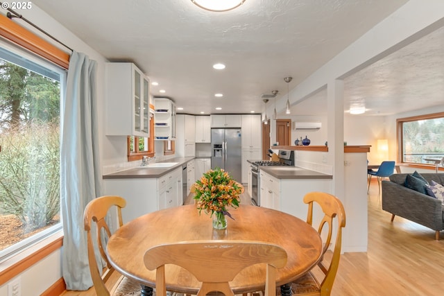 dining area with recessed lighting, light wood-style floors, and a wall mounted AC