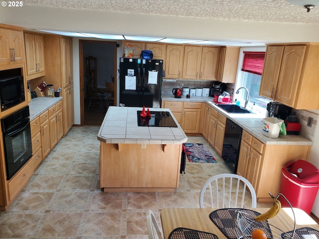 kitchen featuring black appliances, tile countertops, a center island, and tasteful backsplash