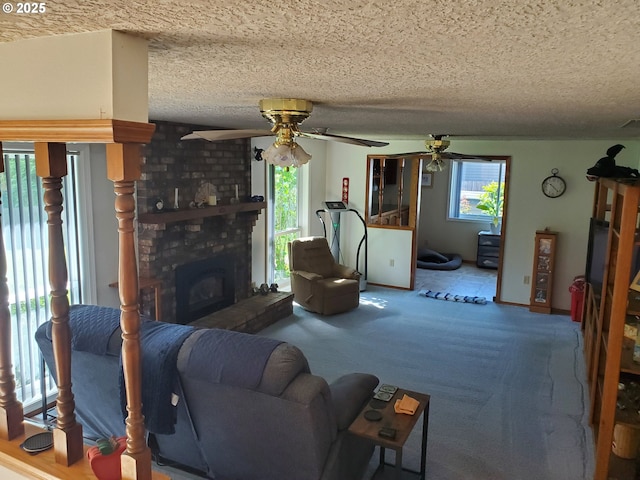 living room featuring ceiling fan, a textured ceiling, and carpet