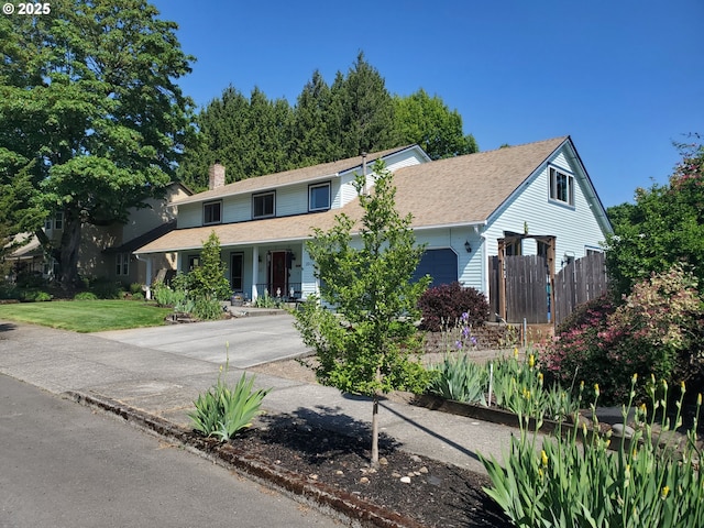 view of front of home with a chimney, an attached garage, covered porch, fence, and concrete driveway