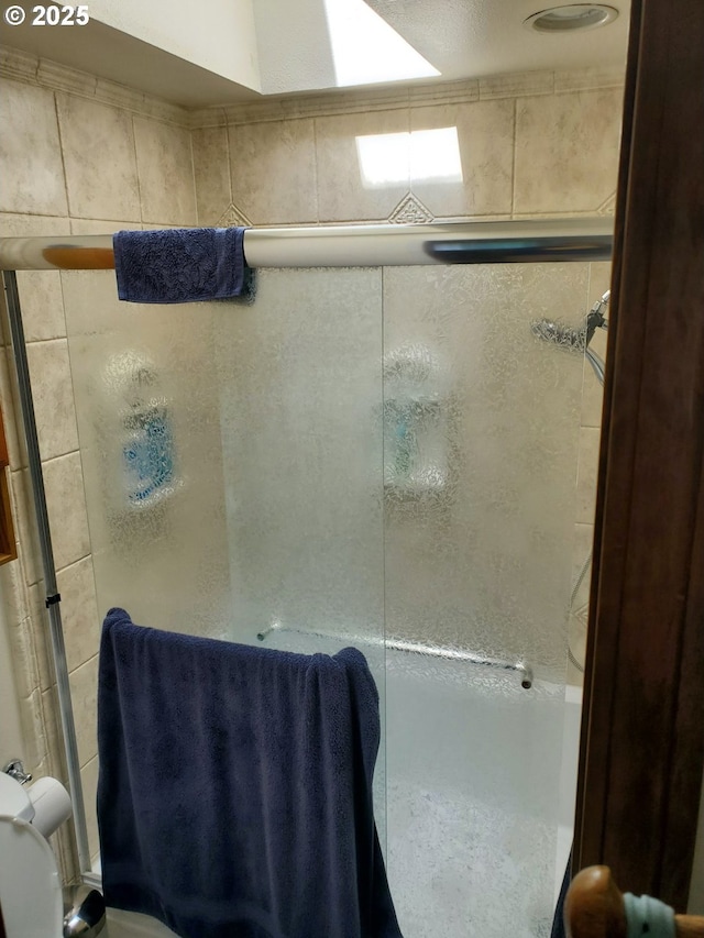 bathroom with a shower stall and toilet