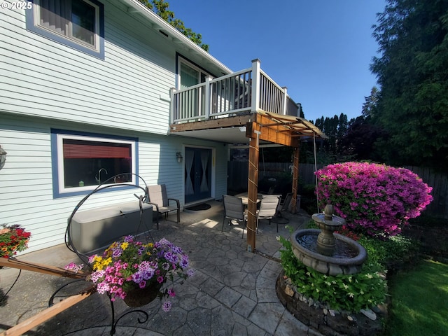 view of patio with fence and a balcony