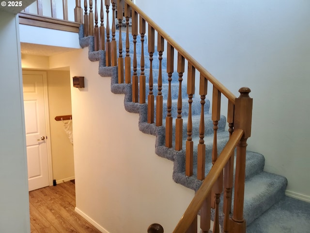 staircase featuring baseboards and wood finished floors