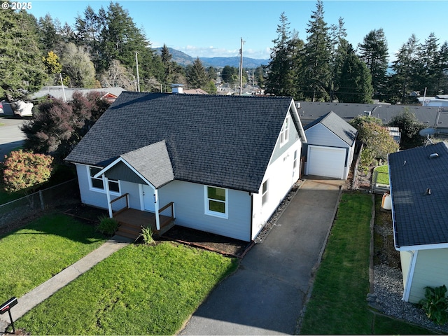 view of front of home with a garage, an outdoor structure, and a front yard