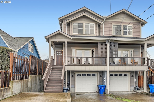 view of front of house featuring stairs, a porch, an attached garage, and fence