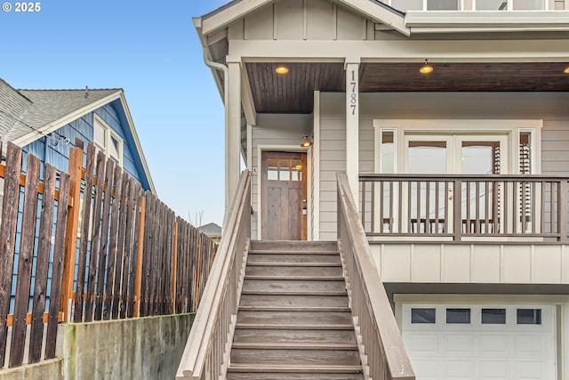 entrance to property featuring a garage, a porch, and board and batten siding