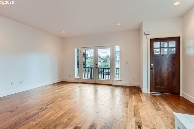 entrance foyer featuring baseboards, french doors, light wood-type flooring, and recessed lighting