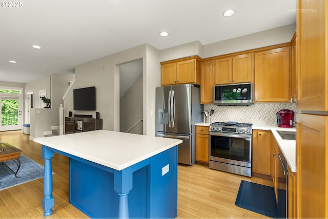 1902 NE 48th Way, Hillsboro, OR 97124 - kitchen with appliances with stainless steel finishes, open floor plan, light wood-style floors, backsplash, and light countertops