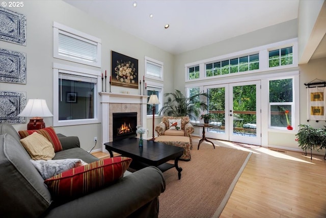living area with french doors, recessed lighting, wood finished floors, and a fireplace