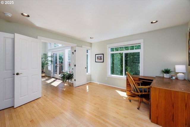 home office featuring light wood-type flooring, baseboards, and a wealth of natural light