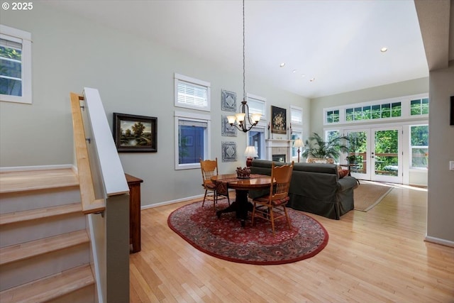 dining room featuring an inviting chandelier, stairs, wood finished floors, baseboards, and recessed lighting
