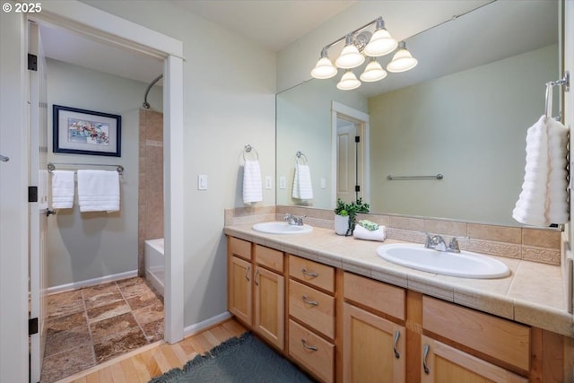 full bath with double vanity, a sink, baseboards, and tub / shower combination